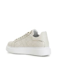 Zapatillas de cuero blanco acolchado con una suela de goma blanca gruesa, que presentan cordones redondos y una textura suave en la parte superior.