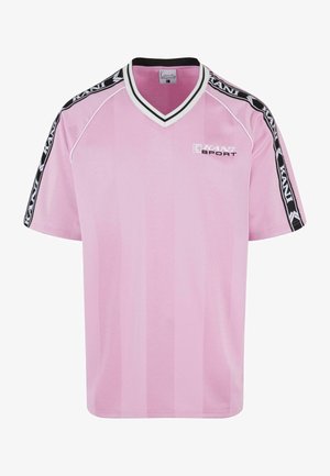 Vaaleanpunainen urheiluostos, jossa on V-mallinen kaula-auko ja mustat olkavarret. Edessä on "KANI SPORT" -logo valkoisena. Valmistettu hengittävästä kankaasta.