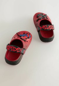 Zoccoli di plastica rossi presentano design del personaggio Spider-Man sul davanti e cinturini regolabili con il testo "SPIDEY" e "MILES" in caratteri in grassetto.