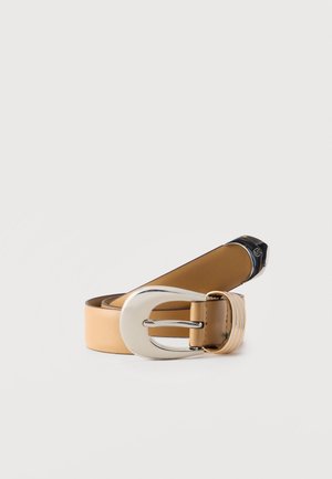 Ταμπά δερμάτινη ζώνη, τυλιγμένη με μια μεγάλη γυαλιστερή ασημένια οβάλ αγκράφα και ένα χρυσό στοιχείο κοντά στην αγκράφα σε απλό φόντο.