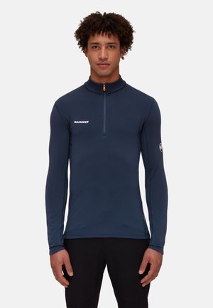 Heren navy lange mouw zip-up top gemaakt van gladde, rekbare stof. Kenmerken een hoge kraag, oranje rits en logo op de borst en mouw.
