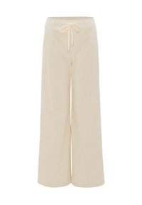 Pantalon beige large en velours côtelé avec taille élastique et cordon à l'avant, conçu pour un usage décontracté.