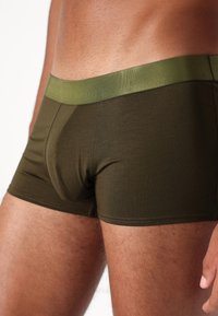 Olivgröna boxerkalsonger med en matchande elastisk midjeresår, med en slät, åtsittande design och platta sömmar för komfort.