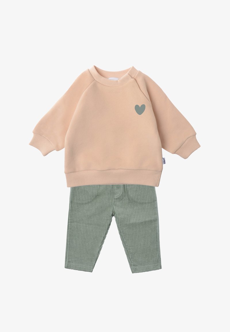 Peach sweatshirt with a green heart graphic and ribbed mint green corduroy pants. Soft material, relaxed fit, and elastic cuffs.