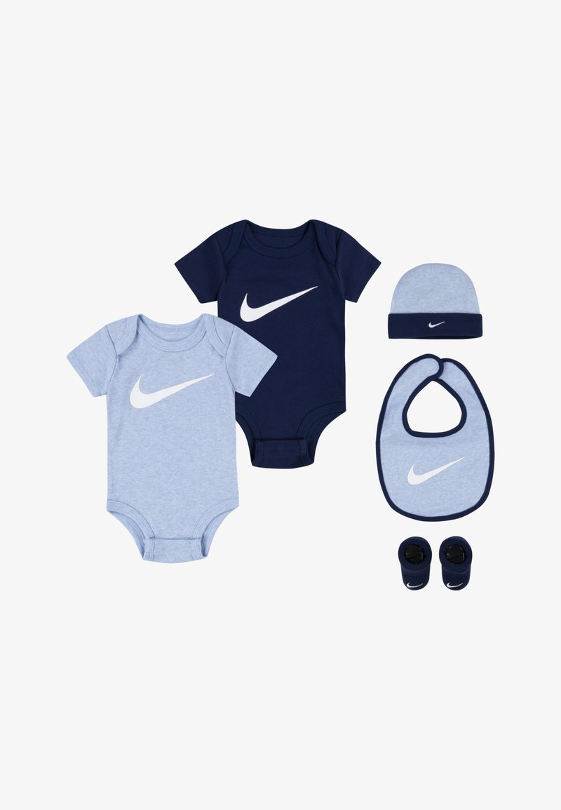 Due bodysuit a maniche corte, uno azzurro chiaro e uno blu navy, abbinati a un berretto, un bavaglino e delle scarpine. Ognuno presenta un grande logo Nike bianco.