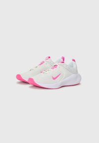 White athletic shoes with pink accents, featuring a mesh upper, rounded toe, and thick white sole with textured grip.