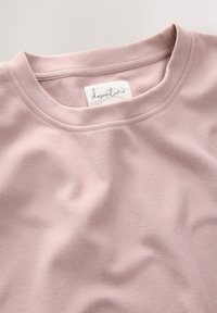 T-shirt rosa chiaro con scollatura a girocollo e texture morbida. Caratterizzato da un'etichetta tessuta con la scritta "downtime" all'interno del colletto.