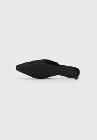 Schwarzer, spitz zulaufender High-Heel-Schuh mit einem weichen, strukturierten Obermaterial. Schlanker Stiletto-Absatz und gummierte Sohle mit geriffeltem Muster für besseren Halt.