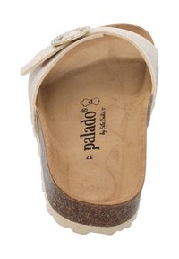 Beige slip-on sandaal met een kurken voetbed, met een decoratieve zilveren knop en textuurbanden. Het interieur heeft een zachte, gladde afwerking.