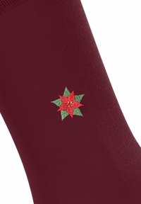 Bordowy skarpetka z haftowanym zielonym i czerwonym wzorem w gwiazdkowy ostrokrzew, podkreślająca świąteczny motyw.