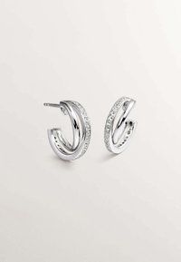 Pendientes de aro de plata con un diseño elegante de forma curva y adornados con cristales transparentes a lo largo de un borde.