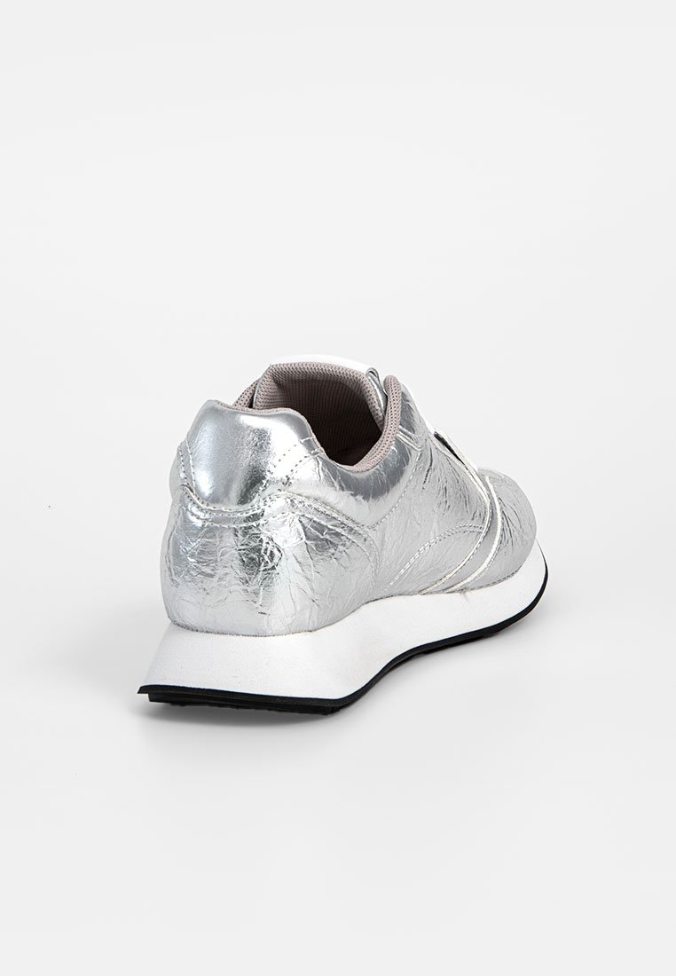 Baskets métalliques argentées vues de l'arrière, avec une semelle blanche à motif noir et un revêtement intérieur gris.