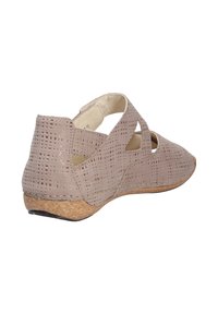 Beige geperforeerde schoen met een lage kurken wedge-zool, voorzien van uitsnijdingen en een open achterkant voor ademend vermogen.