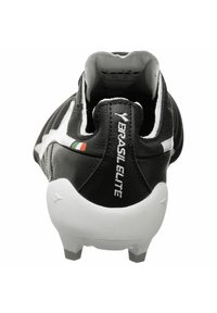 Scarpa da calcio in pelle nera con una striscia di accento bianca, tacco rialzato e tacchetti moldati. Presenta un'etichetta con "BRASIL ELITE" e la bandiera italiana.