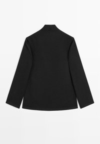 Giacca nera a maniche lunghe con vestibilità rilassata, dotata di colletto rotondo e texture liscia. La vista posteriore evidenzia il design semplice e le linee pulite.