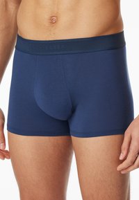 Mörkblå herrboxershorts gjorda av mjukt tyg, med en bred midjeband med präglad logotyp och en tät passform.