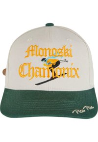 Căciulă cu coroana bej și vizieră verde. Prezintă brodat "Monoski Chamonix" în portocalie și albastră, împreună cu un grafic cu schior. Material texturat.