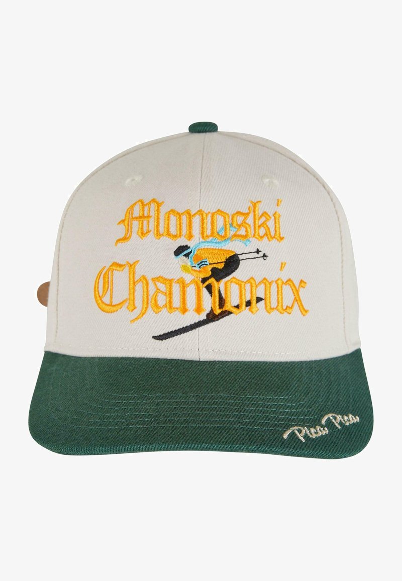 Căciulă cu coroana bej și vizieră verde. Prezintă brodat "Monoski Chamonix" în portocalie și albastră, împreună cu un grafic cu schior. Material texturat.