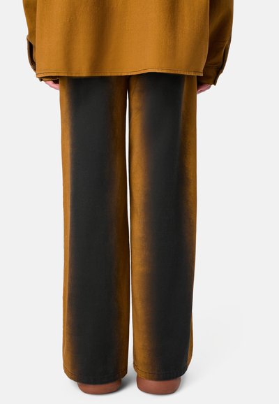 Pantaloni a gamba larga con gradiente marrone e nero, realizzati in tessuto morbido, con una texture liscia e una vestibilità rilassata. L'orlo è rifinito in modo ordinato.