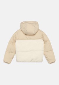 Giacca puffer beige con cappuccio, caratterizzata da un pannello di sherpa bianco e soffice sulla schiena, polsini a coste e un design trapuntato.