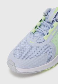 Sneaker Nike bleu clair et vert lime avec une tige en mesh, un design à lacets et une étiquette "Dynamic Fit" sur le côté.