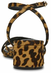 Leopardmønstrede hæle sandaler med en tekstureret, kunstig pels øverdel, sorte stropper og en tykk hæl for ekstra støtte. Justerbar ankelsnor medfølger.