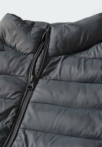Black quilted puffer jacket with a high neck and front zipper, featuring a smooth, shiny texture and contrasting stitching details.