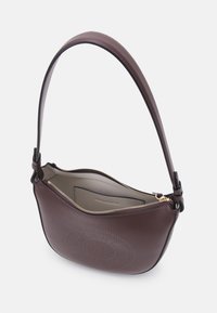 Sac à bandoulière en cuir marron avec logo circulaire embossé, fermeture éclair dorée et poche intérieure beige, présenté ouvert vu de dessus.