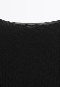 Black knit top featuring a textured pattern with a wide neckline and a slight sheen. The material appears lightweight and flexible.