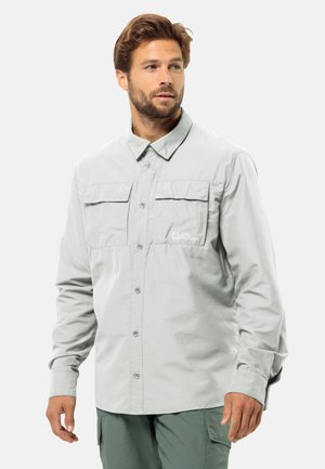 Lichtgrijze longsleeve shirt met knopen aan de voorkant, twee borstzakken en geborduurd logo. Soepele stof met een kraag. 