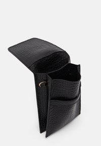 Czarna skórzana torba z tłoczonym wzorem krokodyla, z klapą zapinaną na zatrzask, z dwoma wewnętrznymi przegrodami oraz małą zewnętrzną kieszonką. Gładka faktura.