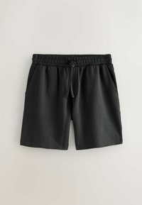 Shorts en tissu noir texturé avec taille élastique et cordon de serrage, dotés de poches latérales, posés à plat sur un fond clair.