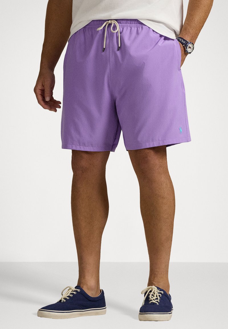 Pantaloni de baie violeți din material ușor, cu un brâu elastic și șnur. Inclus un mic logo albastru pe lateral.