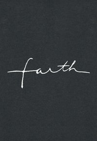 Crna majica s rebrastom teksturom na kojoj je u bijelom rukom pisanoj iscrtan natpis "earth" u sredini. Jednostavan dizajn bez dodatnih grafika.