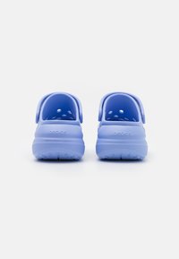 Clog-uri din cauciuc de culoare albastră, cu un braț la spate, orificii de ventilare și o talpă texturată pentru aderență, concepute pentru confort și ușurință la purtare.
