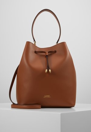 Brązowa skórzana torba typu bucket z zapięciem na sznurek, pojedynczą rączką, odpinanym paskiem na ramię oraz małym, złotym logo Ralph Lauren z przodu.