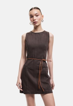 Vestido marrón sin mangas con un torso ajustado y una falda acampanada. Presenta un cinturón de lazo marrón y bolsillos frontales. Textura de tela suave.