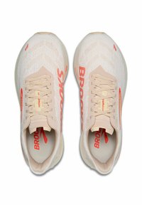 Scarpe da corsa beige chiaro con una parte superiore in maglia testurizzata. Presentano accenti corallo vivaci e un branding dettagliato. Design con lacci e colletto imbottito.