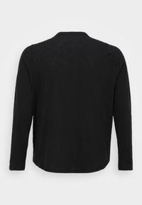 Camisola preta de manga longa com bainha arredondada, decote redondo e tecido macio e leve. Sem gráficos ou enfeites visíveis.