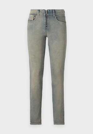 Jeans skinny em denim azul claro, com fecho na frente, cinco bolsos e um efeito desbotado com variações sutis de cor.