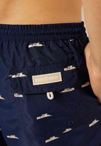 Námořnické plavky s jemným námořním vzorem, elastickým pasem, boční kapsou a textilním štítkem se španělským nápisem "COAST TO COAST."