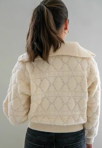 Crème-kleurige cropped trui met een gestructureerd ruitpatroon, geribbeld boord en manchet, en zacht, pluche materiaal.