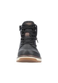 Botín negro de cuero hasta el tobillo con parte superior de textil, cierre de cordones en la parte delantera, cremallera lateral, acentos de cuero marrón y una suela de goma de color claro.