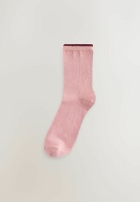 Chaussette rose pâle avec une texture lisse, coupe droite et bande rose foncé en haut. Bout arrondi sans motifs ni ornements.
