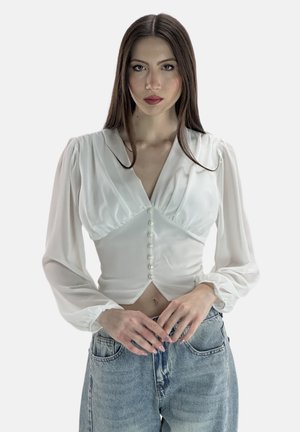 Weiße Bluse mit langen, puffärmeligen Ärmeln, tiefem V-Ausschnitt und Perlenknopfdetails an der Vorderseite. Glattes Material mit taillierter Passform.