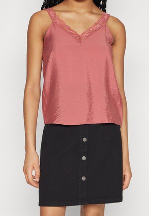 Haut sans manches rose avec une bordure en dentelle au niveau du col, associé à une jupe en denim noire avec une fermeture à boutons à l'avant.