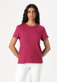 Kraftig rosa bomull T-skjorte med korte ermer og rund hals, med en glatt tekstur og enkel design.