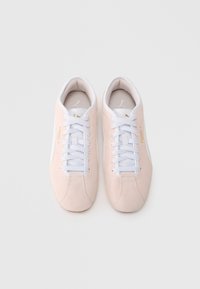 Ανοιχτό ροζ σουέντ αθλητικά παπούτσια με λευκά κορδόνια και σόλα, με χρυσές λεπτομέρειες και στρογγυλεμένο σχέδιο μύτης.