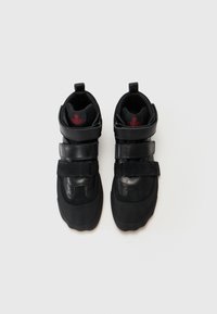 Zwarte high-top sneakers met een gestructureerd oppervlak, voorzien van leren en suède accenten, klittenband-en een gevormde rubberen zool.