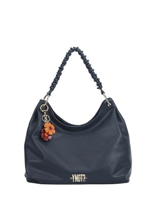 Borsa nera con texture, manico intrecciato, portachiavi a forma di fiore e logo "YNOT?" sul davanti, mostrata su sfondo bianco.